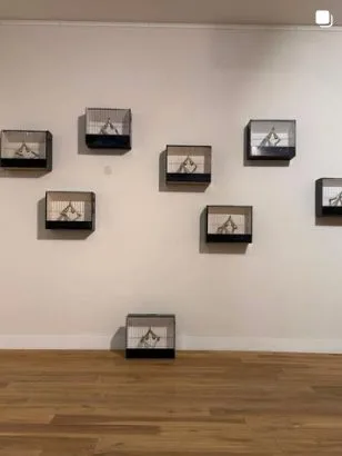 Expositiewand met serie objecten in kastjes