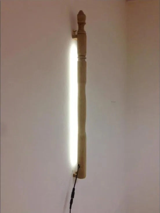 Wandlamp van een oude houten trapbaluster met led-licht