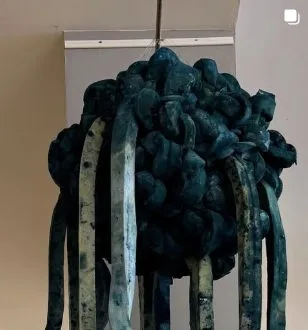 Hangende sculptuur van geknoopt blauwgroen textiel